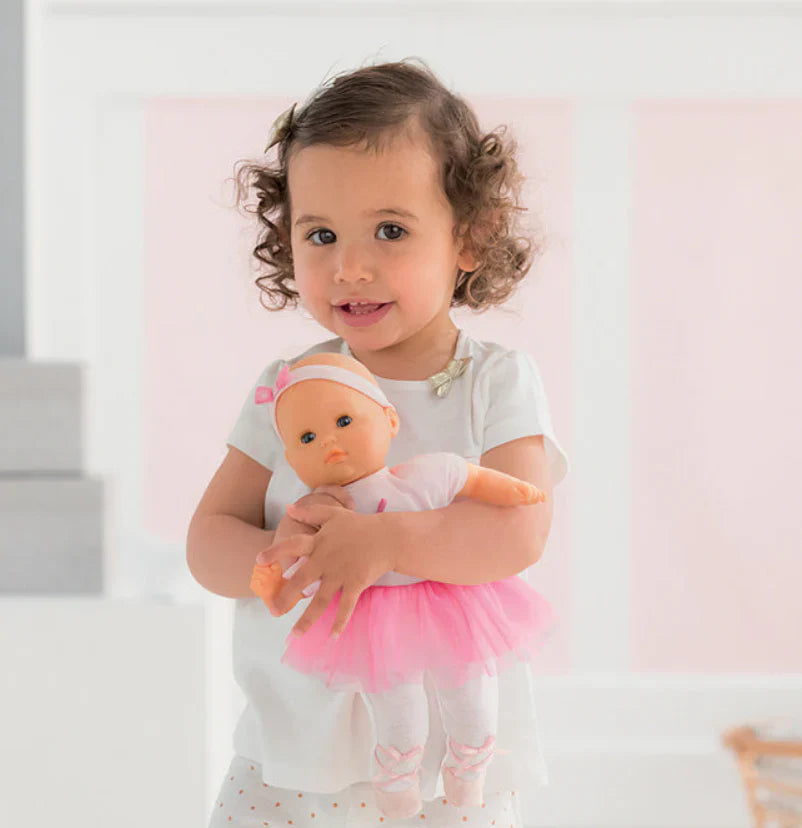 Young girl holding a ballerina doll.