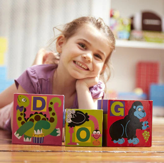 Young girl with large alphabet blocks.