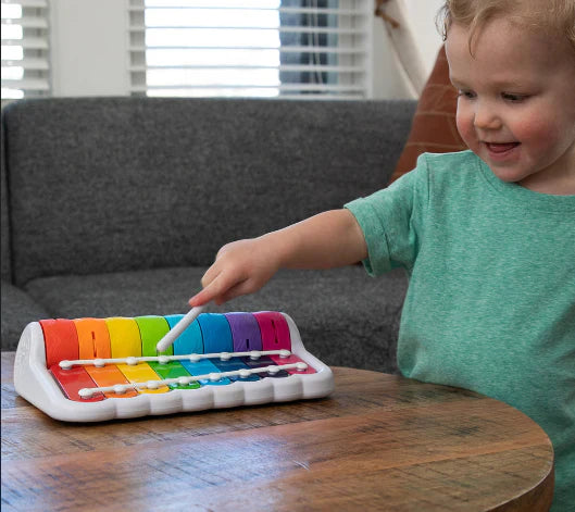 Toddler playing with xylophone toy.